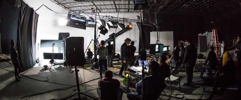 Complex film set with numerous crew, lights, talent, and a lot of equipment